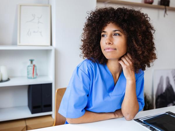 a person in blue scrubs sitting at a table