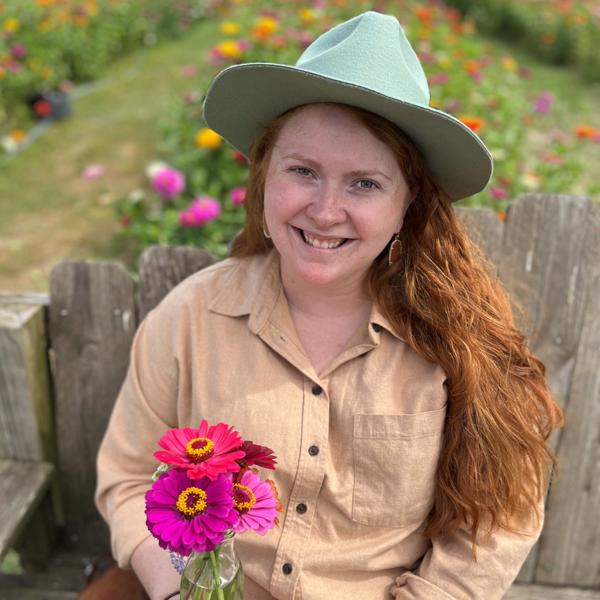 a person sitting on a bench holding flowers