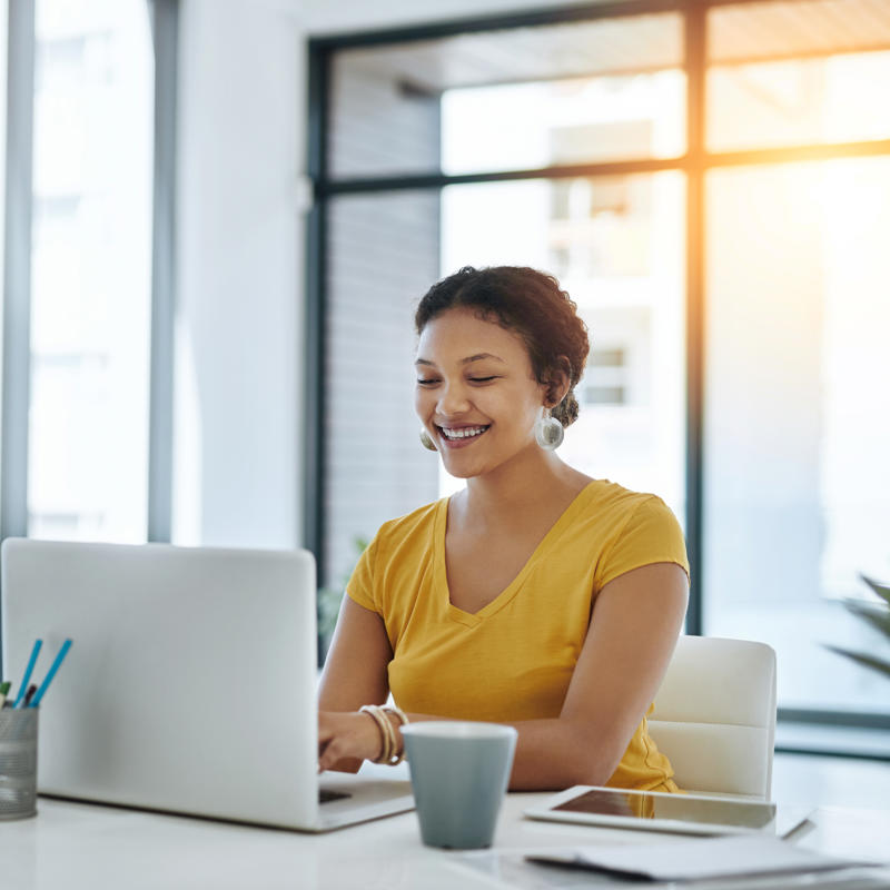 a woman smiling at a laptop