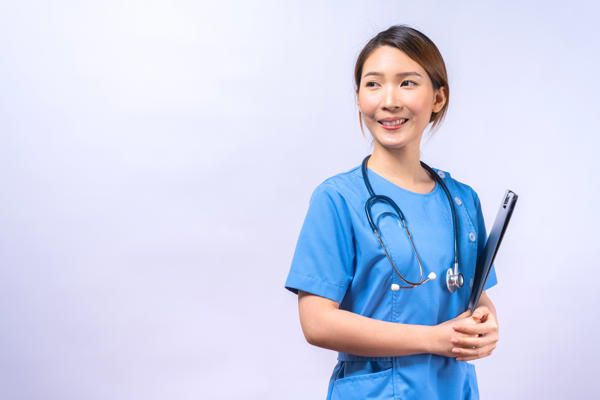 a woman in blue scrubs holding a clipboard