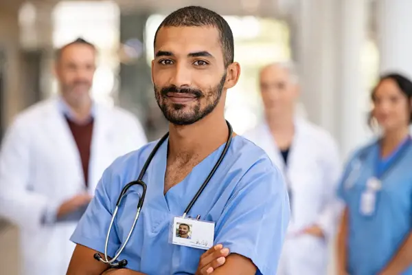 a man in blue scrubs with a stethoscope around his neck