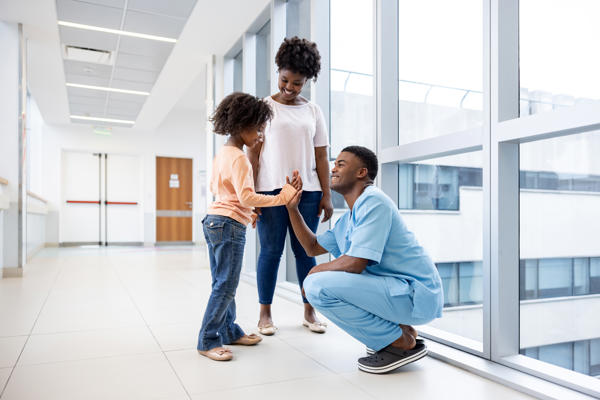 a person and person standing in a hallway with a child and a person