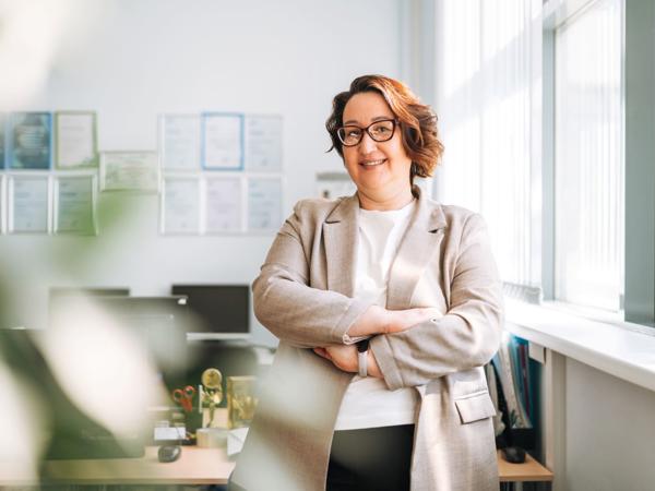 a person in a suit with her arms crossed