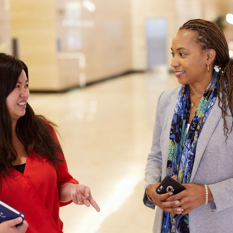 a group of women talking in a hallway