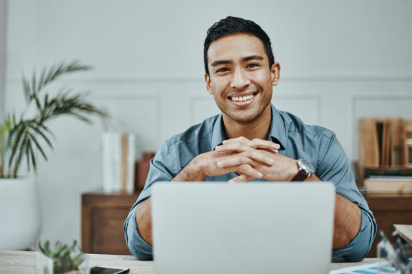 a person sitting at a desk with his hands folded