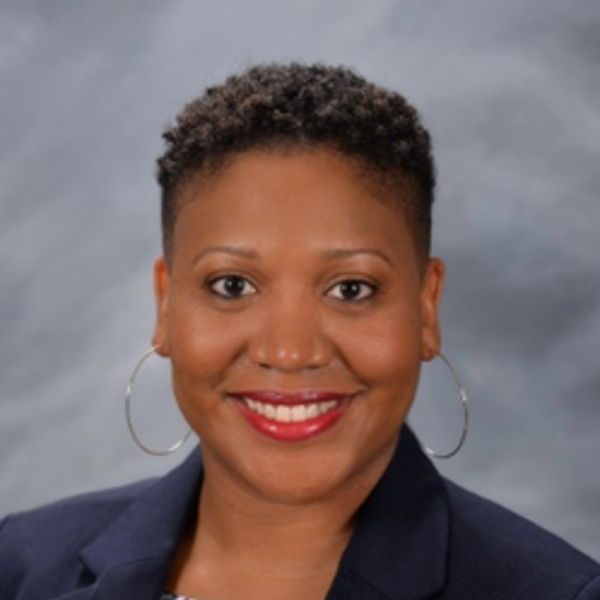 a woman wearing a suit and earrings