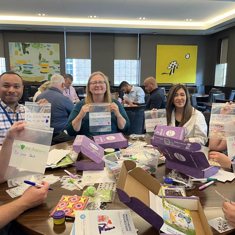 a group of people sitting around a table with boxes of food