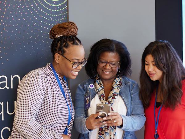 a group of women looking at a phone