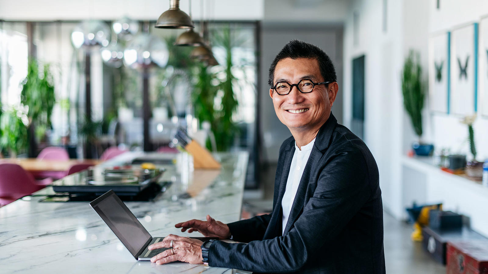 a man sitting at a counter with a laptop