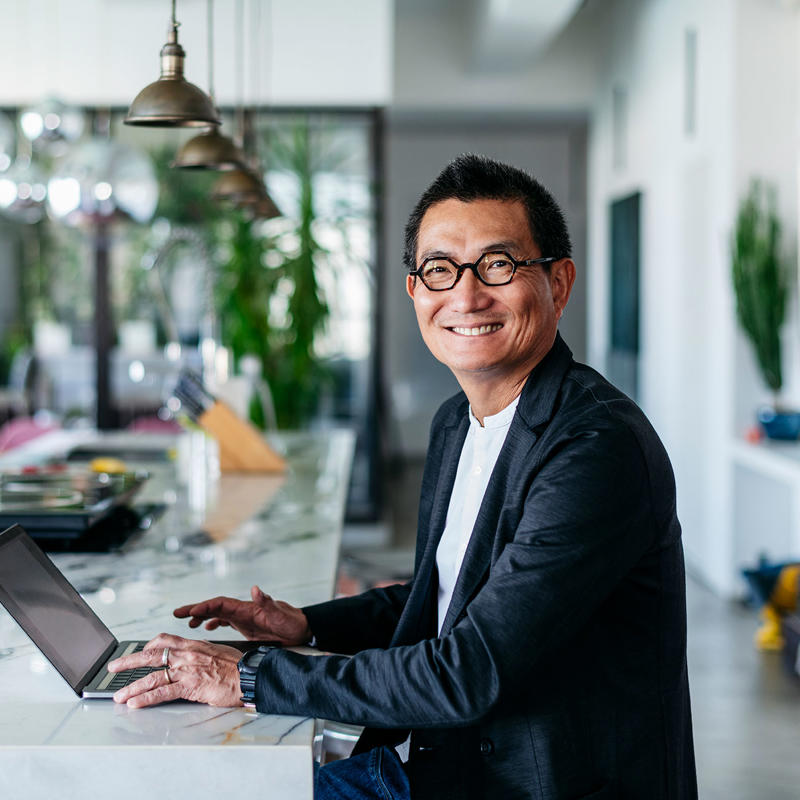 a man sitting at a counter with a laptop