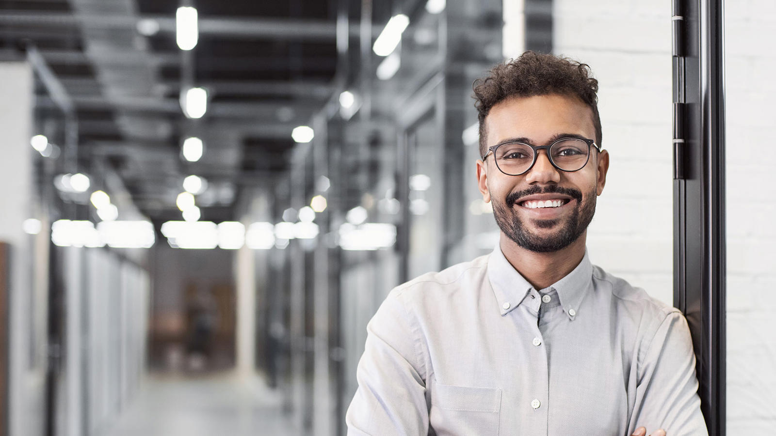 a man with glasses and a beard smiling