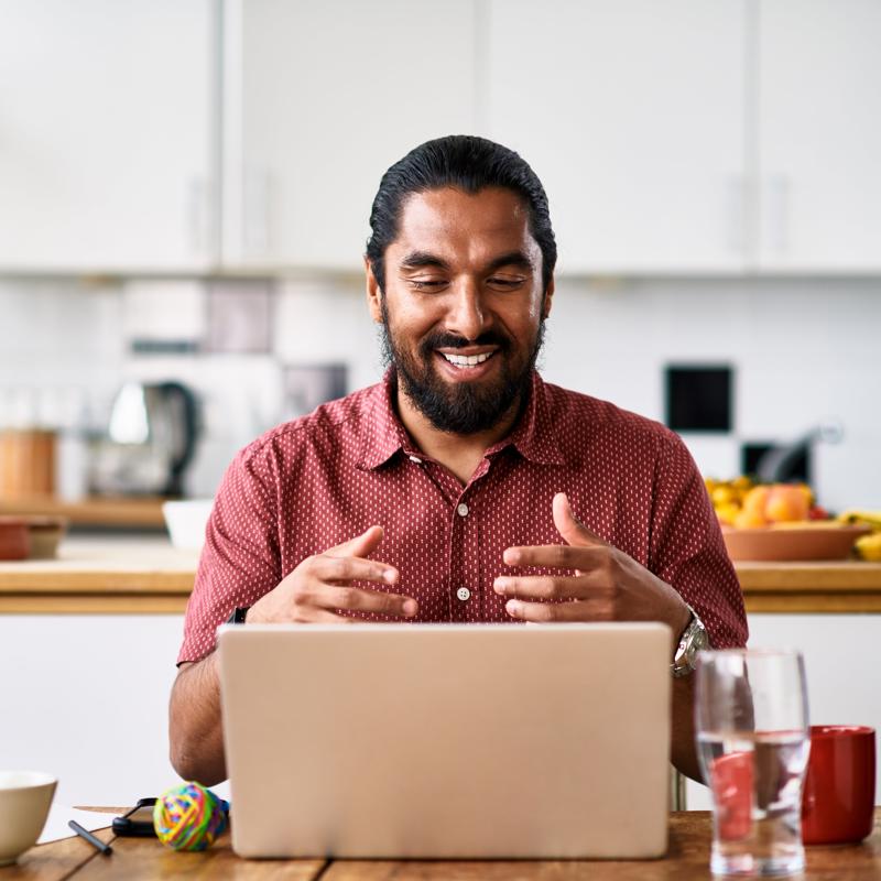 a man sitting at a table with a laptop